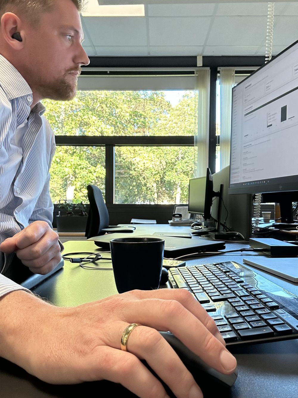 Mads Dahlén Lund-Nielsen i profil ved sit skrivebord, mens han arbejder med en klimadashboard på skærmen